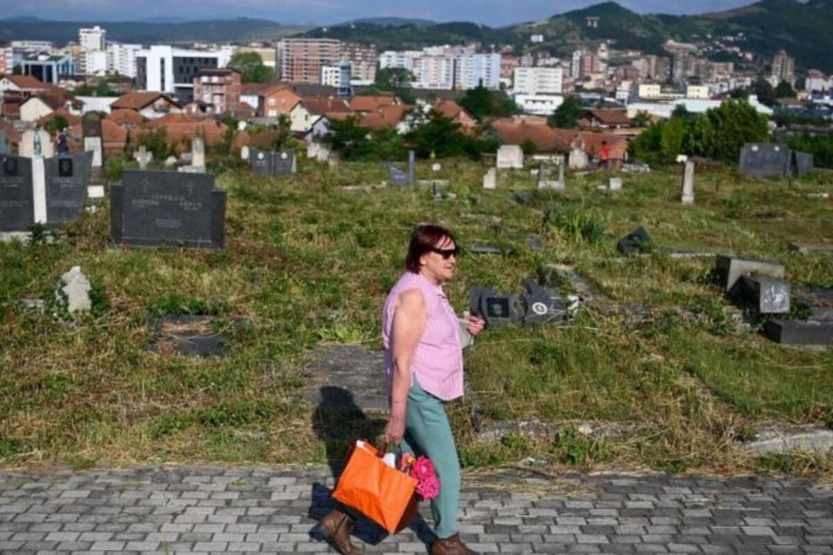 Una mujer visita un cementerio en la ciudad étnicamente dividida de Mitrovica, en Kosovo
