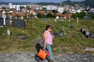 Una mujer visita un cementerio en la ciudad étnicamente dividida de Mitrovica, en Kosovo