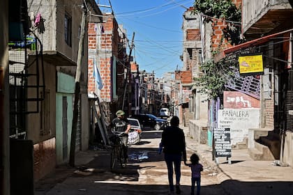 Una mujer y un niño caminan por una calle en la Villa 21-24 en Buenos Aires el 29 de septiembre de 2020