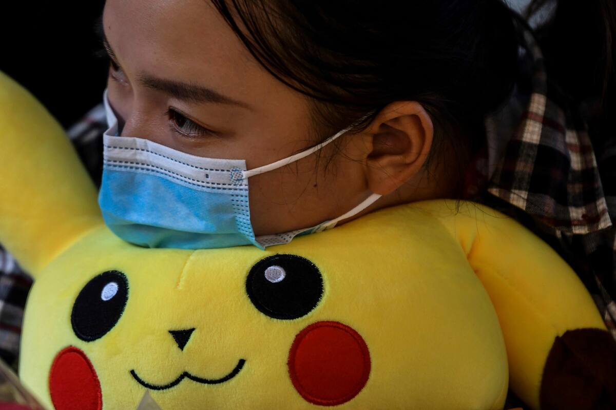 Una mujer y un niño con máscaras faciales como medida preventiva contra el coronavirus Covid-19 dan un paseo en el parque de atracciones Zhongshan en Wuhan, en la provincia central china de Hubei el 26 de septiembre de 2020.