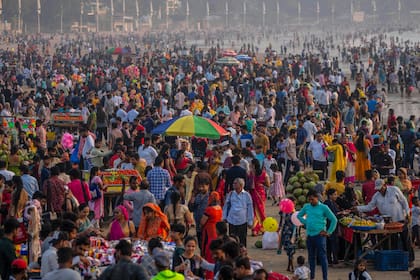 Una multitud de personas abarrota la playa de Juhu, en la costa del mar arábigo, en Mumbai, India, el 13 de noviembre de 2022. (AP Foto/Rafiq Maqbool)