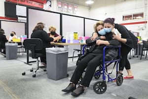 Una nieta abrazando a su abuela de 92 años luego de que ser inoculada contra el coronavirus en Toronto