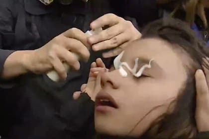 Una niña se ve afectada por gases lacrimógenos rociados por la policía antidisturbios durante una protesta frente al Congreso el 11 de septiembre de 2024.