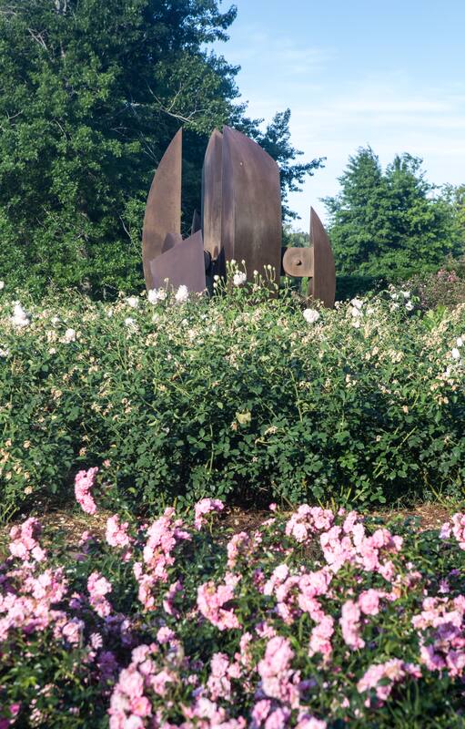 Una obra de Alberto Bastón Díaz que se detecta en el jardín, rodeada de un rosedal en flor.