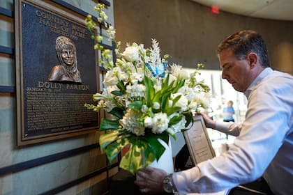 Una ofrenda floral es colocada cerca la placa de Dolly Parton en el Salón de la Fama de la Música Country el martes 25 de agosto de 2026