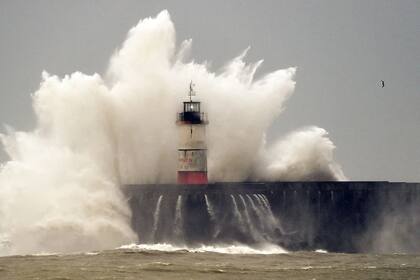 Una ola choca contra un faro en Inglaterra