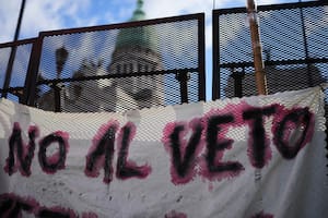 Una pancarta con el mensaje "No al veto" cuelga de una valla frente al Congreso