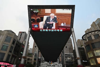 Una pantalla gigante en un shopping de Pekín muestra la visita de Henry Kissinger