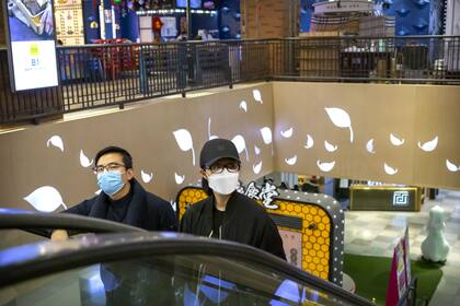 Una pareja con barbijos en un shopping de Pekín