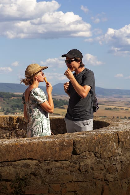 Una pareja de turistas alemanes toma un gelatto en el mirador de Pienza.