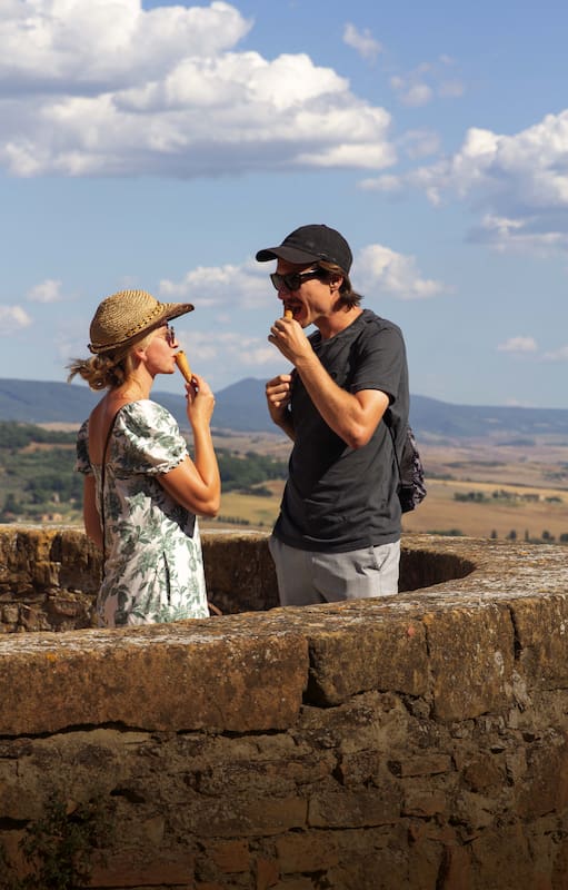 Una pareja de turistas alemanes toma un gelatto en el mirador de Pienza.