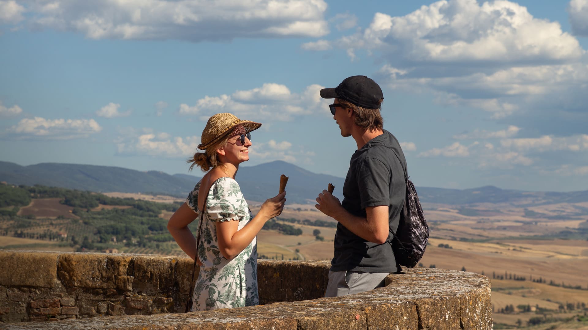 Una pareja de turistas alemanes toma un gelatto en el mirador de Pienza.