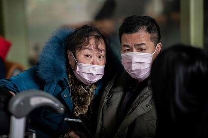 Una pareja de viajeros en el aeropuerto internacional de Pekín, ayer, con barbijos por temor al virus