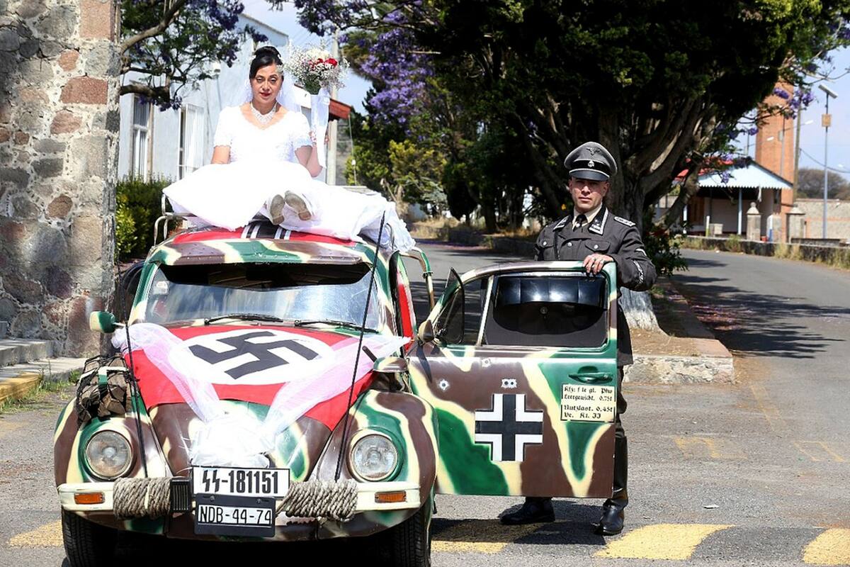 Una pareja junto a la carroza nupcial de una boda de temática nazi en Tlaxcala (México)
