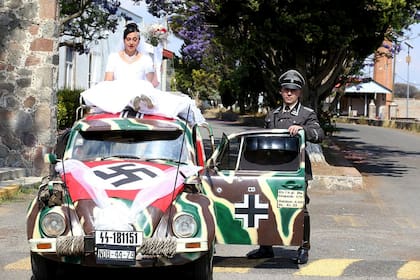 Una pareja junto a la carroza nupcial de una boda de temática nazi en Tlaxcala (México)