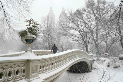 Una persona cruza el puente Bow en Central Park durante la tormenta de invierno en la ciudad de Nueva York