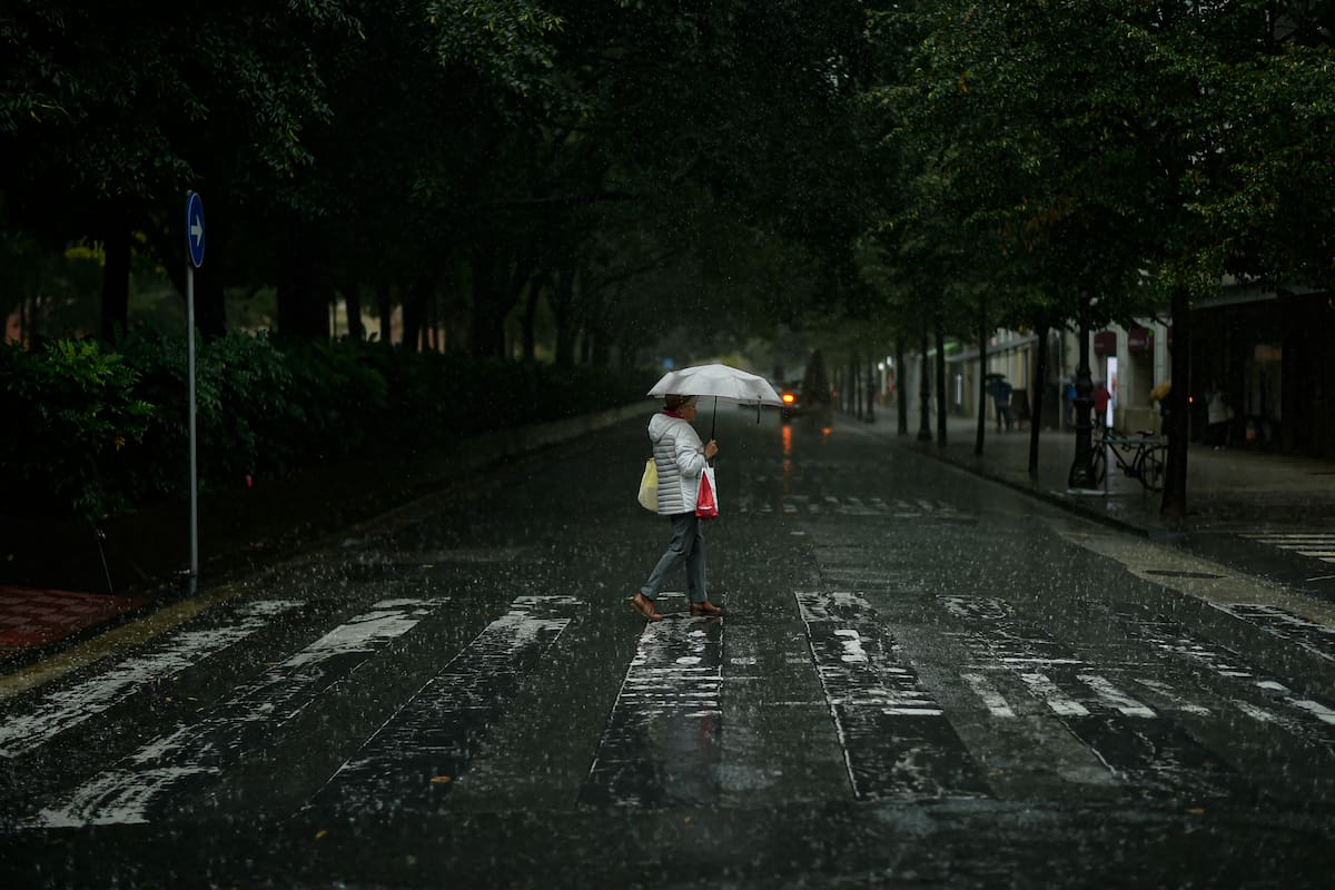 Una persona cruza una calle bajo una tormenta (AP Foto/Álvaro Barrientos)