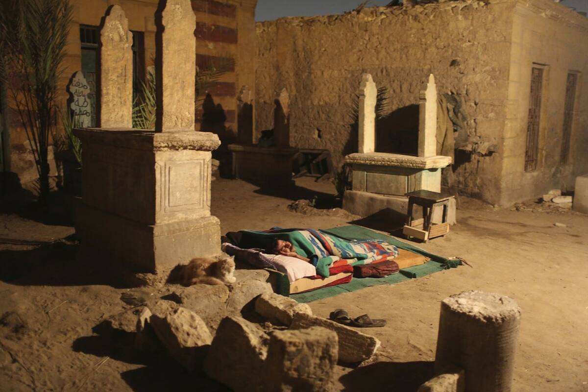 Una persona duerme entre lápidas.