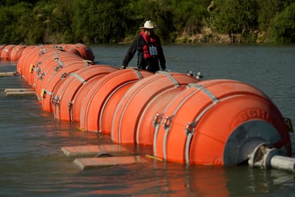 Una persona en kayak pasa al lado de boyas instaladas como barrera en el Río Grande (o Bravo), el 1 de agosto de 2023, en Eagle Pass, Texas (AP Foto/Eric Gay, Archivo)