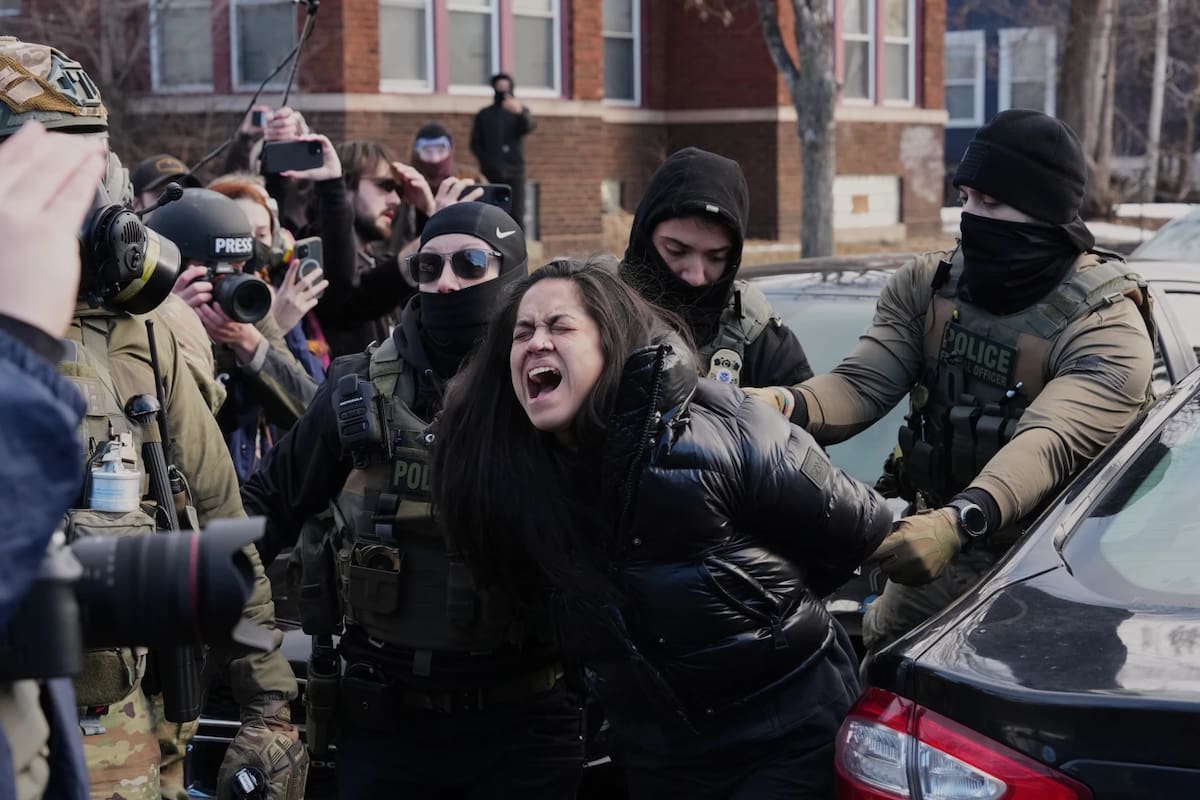 Una persona es detenida por agentes federales cerca del lugar donde Renee Good fue fatalmente baleada por un oficial del ICE la semana pasada, el 13 de enero de 2026
