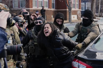 Una persona es detenida por agentes federales cerca del lugar donde Renee Good fue fatalmente baleada por un oficial del ICE la semana pasada, el 13 de enero de 2026