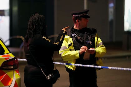 Una persona habla con un oficial de policía, en Reading, Gran Bretaña