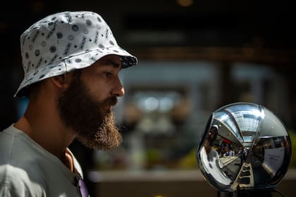 Una persona se coloca frente a un orbe para que le escanee los globos oculares en un punto de registro de Worldcoin en Barcelona