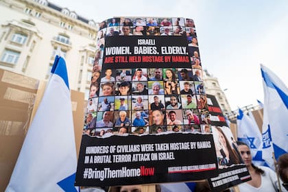 Una persona sujeta un cartel con los rostros de las personas secuestradas durante una manifestación por la liberación de los rehenes secuestrados por Hamas.