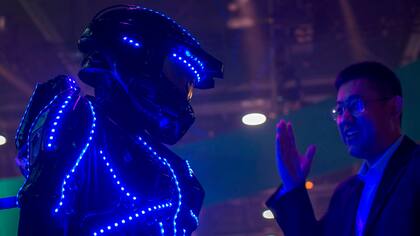 Una persona vestida de "glowbot" atrae a la gente al stand de Hisense