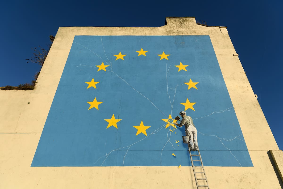 Una pintura del artista Banksy que muestra a un obrero quitando una estrella de la bandera de la Unión Europea