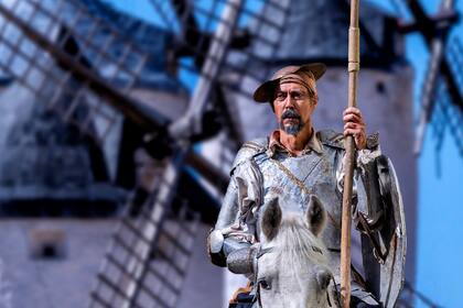 Una representación de Don Quijote, con los molinos de viento detrás