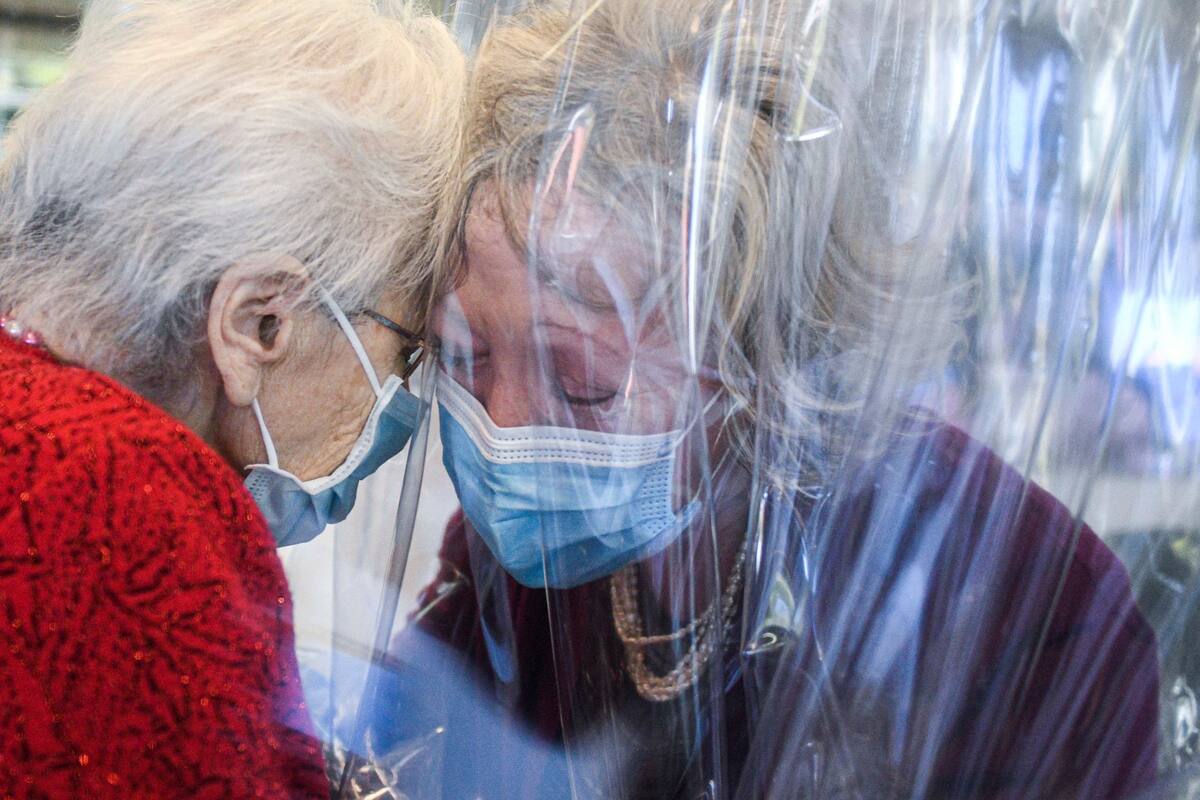 Una residentedel asilo de ancianos Domenico Sartor en Castelfranco Veneto, abraza a su hija a través de una pantalla de plástico en una "Sala de Abrazo" en esta se permite que los huéspedes y sus familias se abrazen, mientras permanecen separados y protegidos