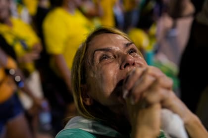 Una simpatizante de Jair Bolsonaro sostiene sus manos en oración mientras observa los resultados parciales luego del cierre de las urnas en la segunda vuelta de las elecciones presidenciales en Río de Janeiro, Brasil, el domingo 30 de octubre de 2022.