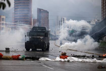 Una tanqueta utiliza un cañon de agua para dispersar la manifestación