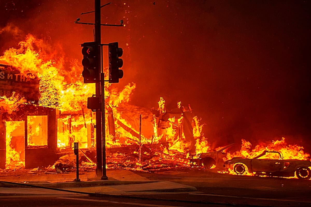 Un bombero vigila el incendio cerca de una casa en Paradise, California