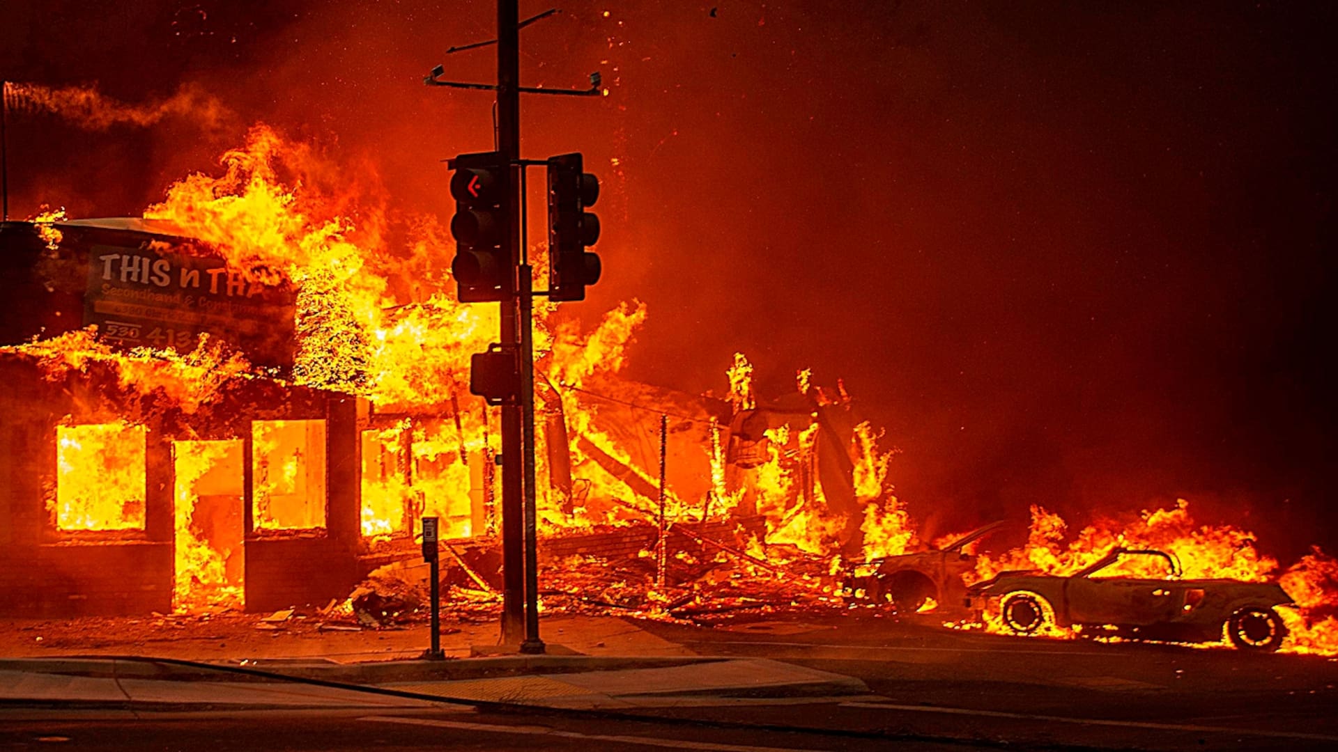 Un bombero vigila el incendio cerca de una casa en Paradise, California