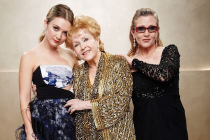 Una tierna foto junto a su abuela Debbie Reynolds y su mamá durante la entrega de los premios SAG, en enero de 2015. Al año siguiente, ambas murieron