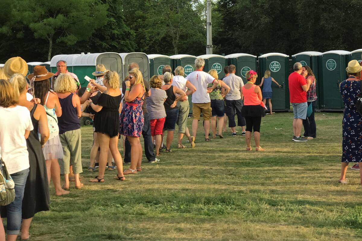 Una típica fila para usar los baños públicos en un evento al aire libre