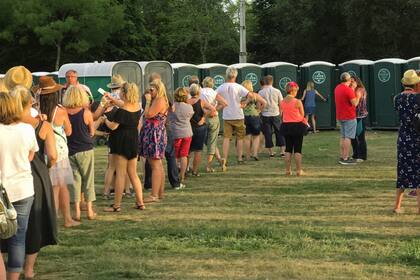 Una típica fila para usar los baños públicos en un evento al aire libre