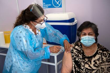 Una trabajadora de la salud administra una dosis de la vacuna Sinovac CoronaVac de China a una persona en un centro de vacunación montado en el Estadio Bicentenario en Santiago, mientras comienza una campaña masiva de vacunación contra el coronavirus en Chile, el 3 de febrero de 2021