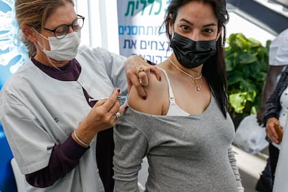Una trabajadora de la salud administra una dosis de la vacuna contra el coronavirus de Pfizer-BioNtech a una mujer embarazada en Clalit Health Services, en Tel Aviv, Israel, el 23 de enero de 2021