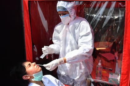 Una trabajadora de la salud toma una muestra de hisopado en Bombay