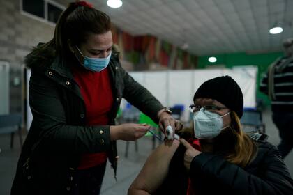 Una trabajadora de salud administra una vacuna AstraZeneca para el COVID-19 en un centro de salud en Buenos Aires, el martes 27 de julio de 2021. (AP Foto/Víctor R. Caivano)
