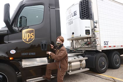Una trabajadora de UPS engancha un camión de UPS a un remolque que contiene envíos de la vacuna contra el coronavirus de Pfizer y BioNTech el 13 de diciembre de 2020 en Lansing, Michigan
