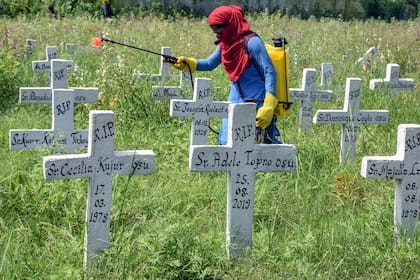Una trabajadora municipal desinfecta un cementerio de la Iglesia Católica Romana después del entierro de personas infectadas con el coronavirus en Ranchi, la India, el 6 de septiembre de 2020