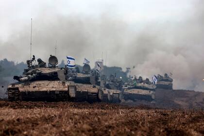 Una unidad de soldados israelíes regresa con sus tanques al lado israelí de la frontera con la Franja de Gaza, después de pasar meses en el territorio palestino participando en batallas con militantes de Hamás, el 28 de enero de 2024, mientras continúan los combates entre los dos bandos beligerantes (Menahem KAHANA / AFP)