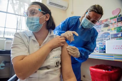 Una vacunadora recibe una inyección de la vacuna Sinovac contra COVID-19 mientras el país vacuna a maestros, policías, bomberos y militares en activo menores de 60 años contra el nuevo coronavirus en Montevideo, Uruguay, el lunes 1 de marzo de 2021.