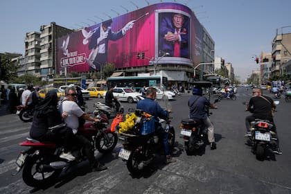Una valla publicitaria que muestra a Trump junto a un mago y las palabras "Parpadea, te has ido", en el centro de Teherán
