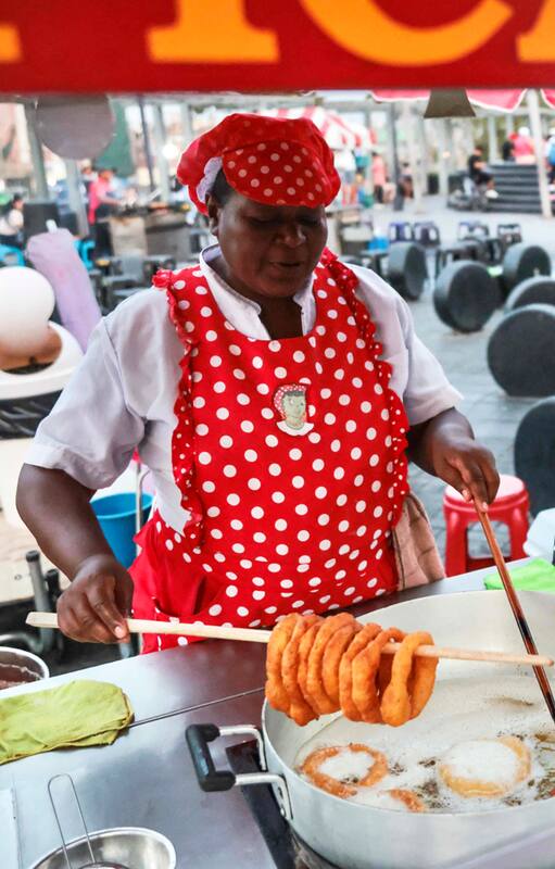 Una vendedora ambulante prepara picarones en Lima