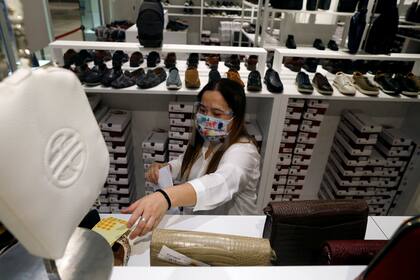 Una vendedora con máscara protectora en una zapateria de Singapur. La vida económica ya se había normalizado de manera parcial desde hace dos semanas